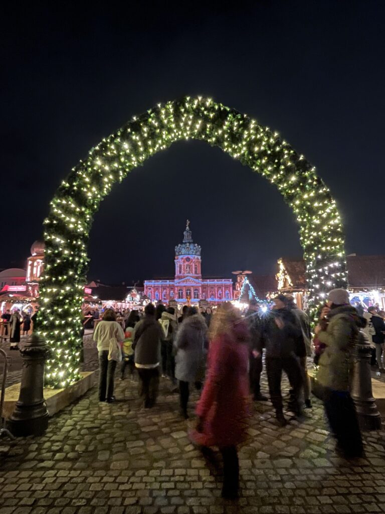 クリスマスマーケットの正門とライトアップされたシャルロッテンブルク城